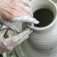 Mãos de artesão torneando uma peça de porcelana Teixeira